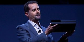 Andrew House, lovingly holding a PlayStation 4