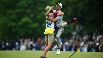 Nick Taylor of Canada celebrates with his caddie after making an eagle putt on the 4th playoff hole to win the RBC Canadian Open