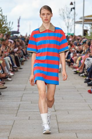 a model walks the Copenhagen Fashion Week runway wearing a striped polo dress