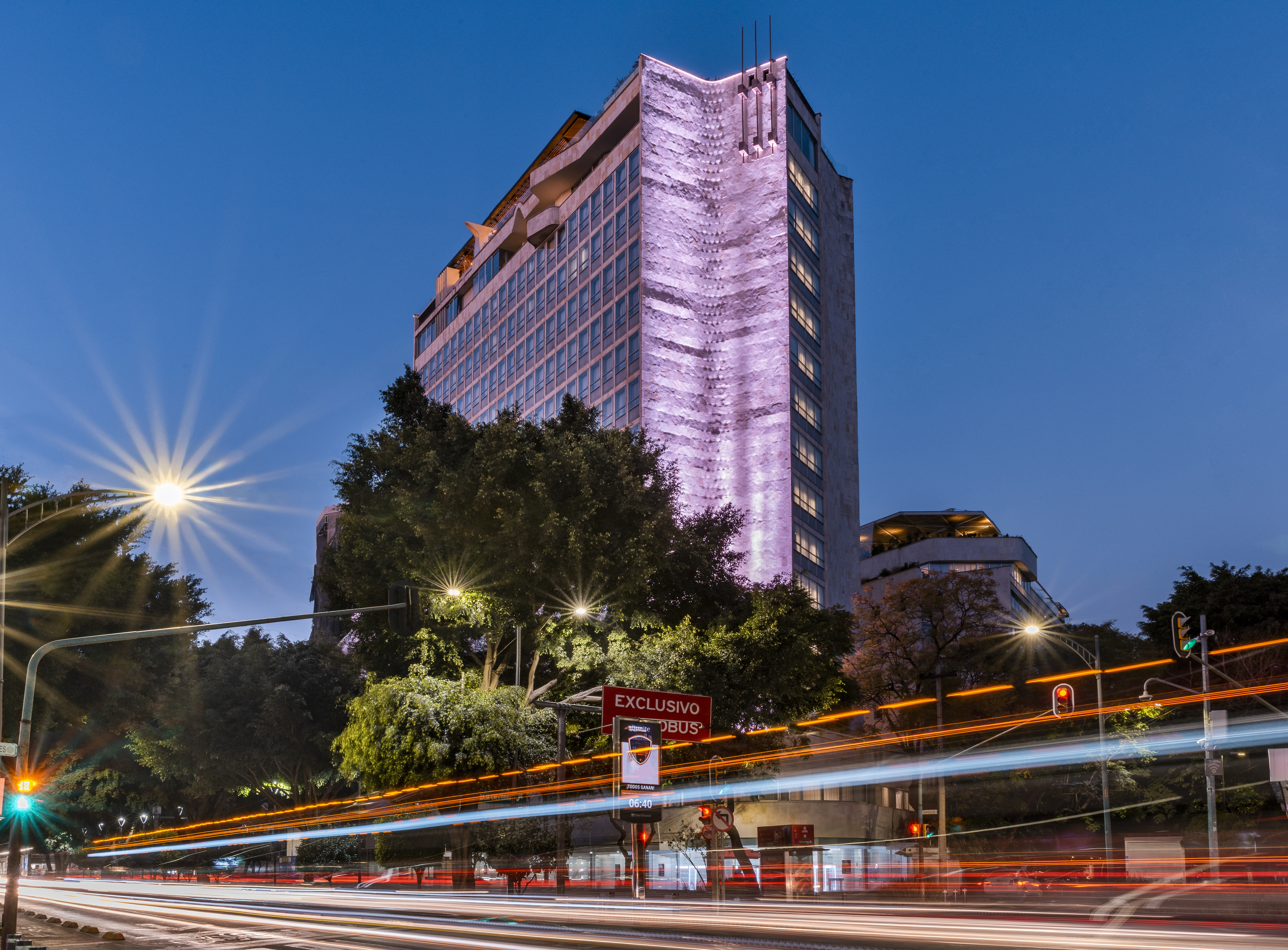 The facade of Andaz Mexico City Condesa at sunset with traffic going by