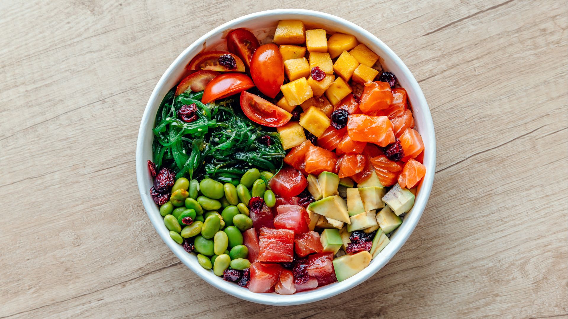 Bowl of poke, featuring edamame beans, mango, salmon, avocado and seaweed