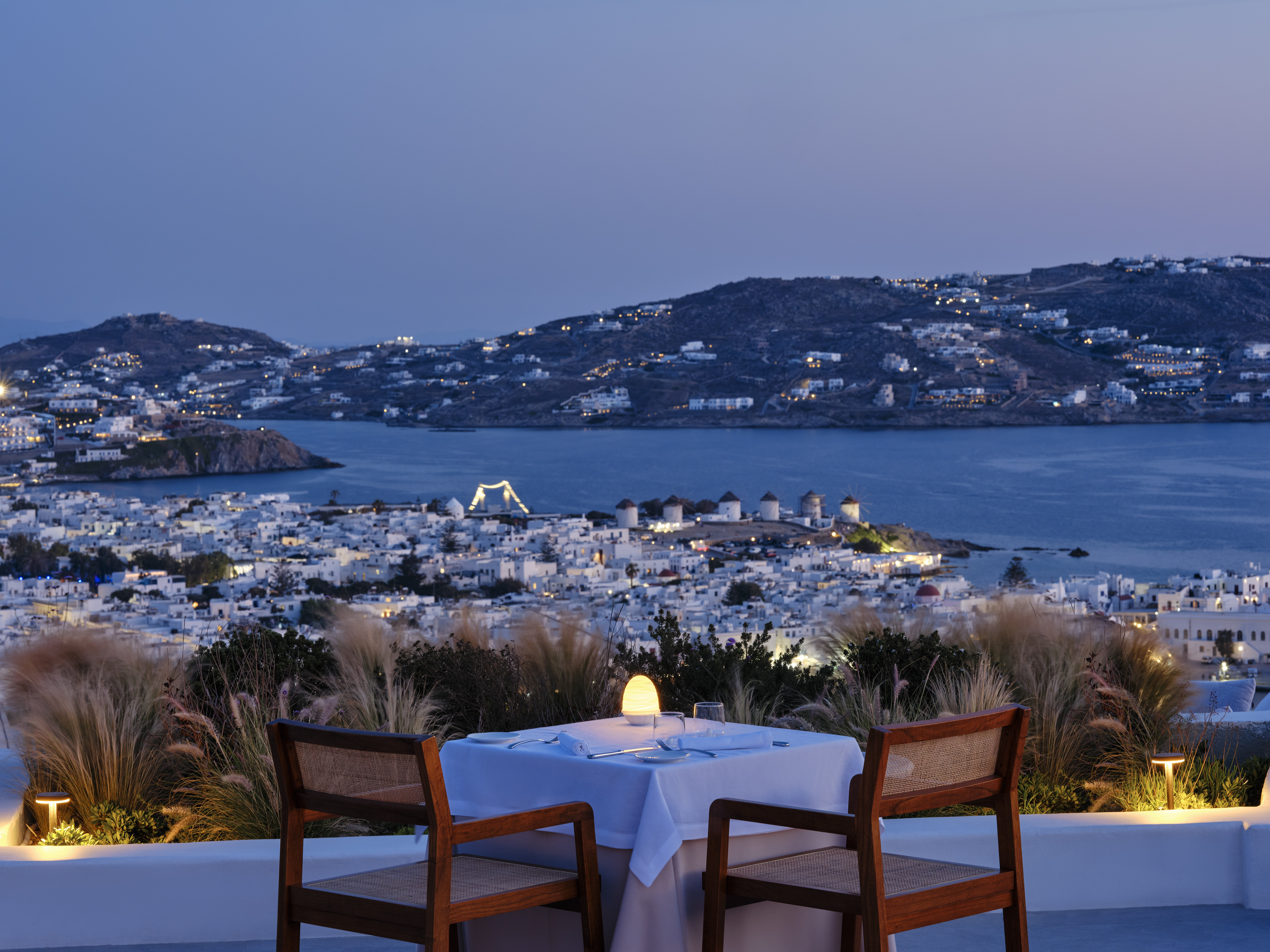 A seaview at blue hour, caught from a panoramic restaurant terrace.
