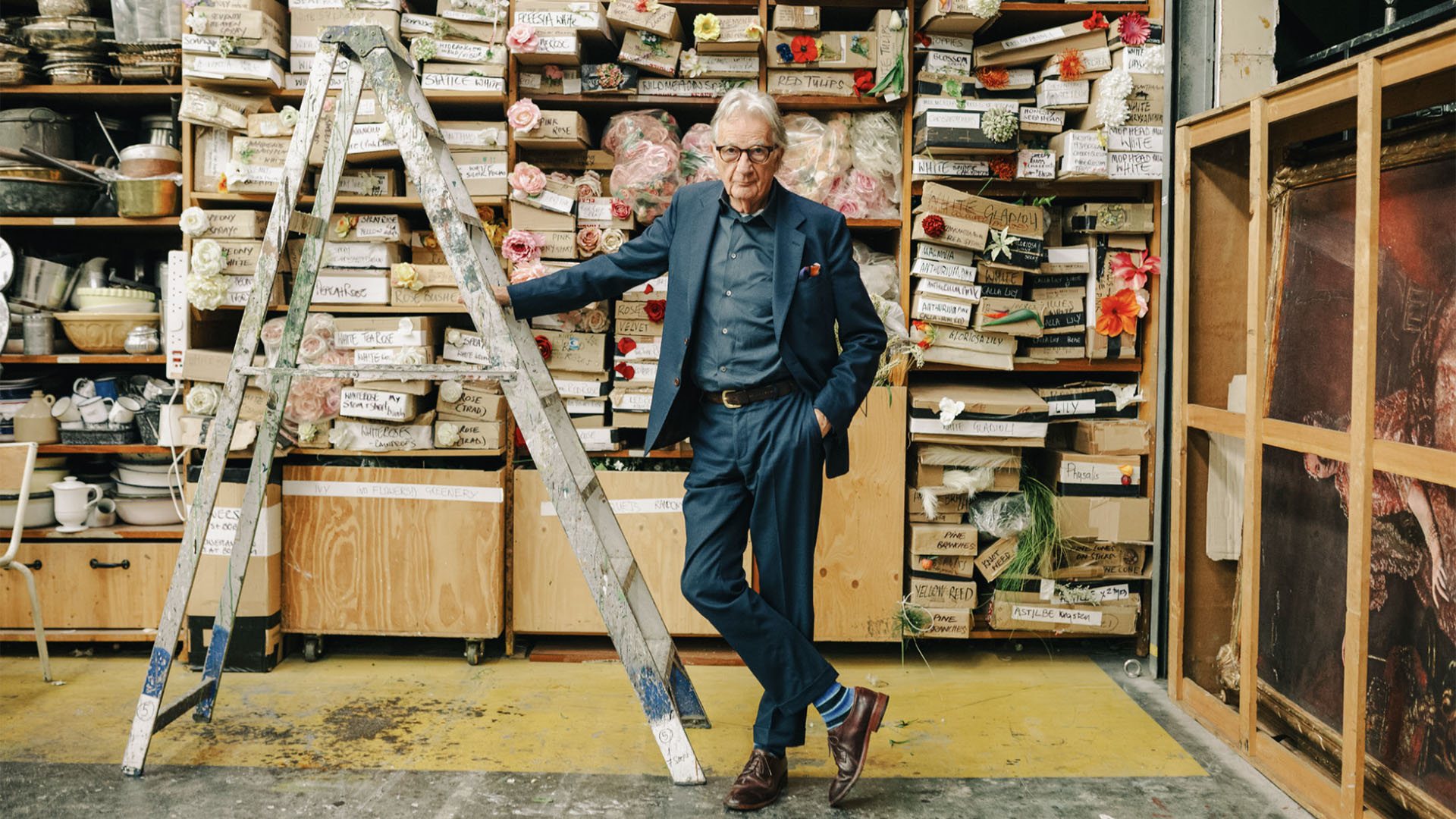 A photo of designer Paul Smith next to a step ladder.