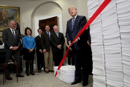President Trump cuts bureaucratic red tape at a White House event in 2017.