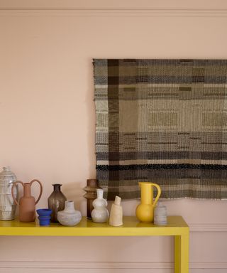 Decorating with primaries - yellow console with selection of ceramics and woven artwork