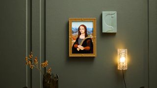 Lego Mona Lisa painting hung on a green wall