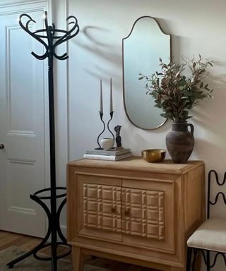 Wavy iron chair with wavy candlestick holder, coat rack and wooden cabinet and mirror