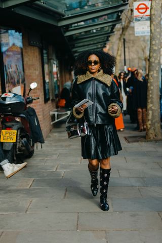 woman wearing leather jacket, leather skirt, and boots