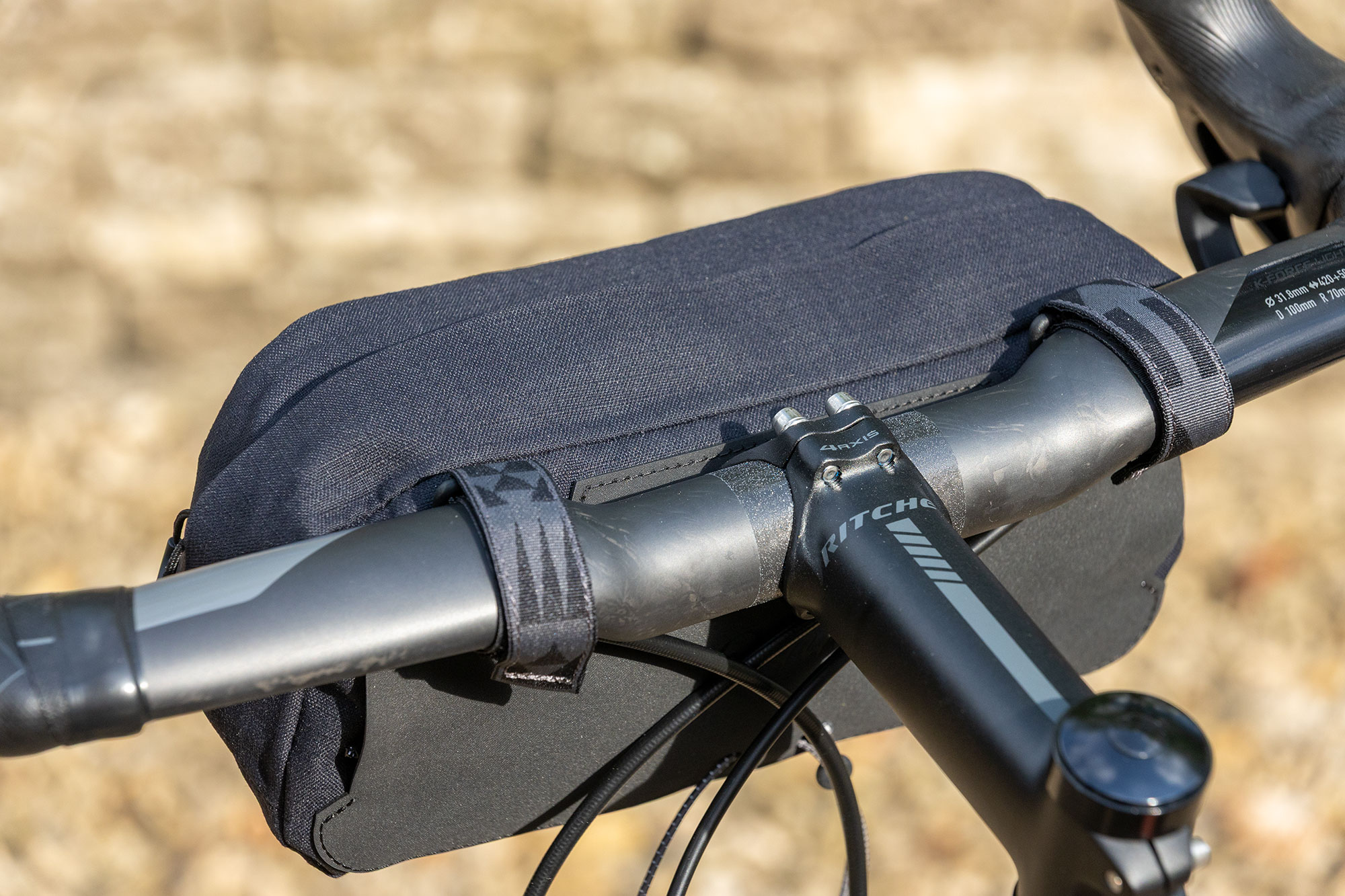 Rapha Explore Bar Bag mounted to handlebars, from rear, three-quarters on