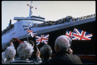 Well-wishers waving British flags as they bid farewell to troops leaving for Falkland Islands