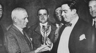 FIFA President Jules Rimet presents the World Cup trophy Uruguayan Football Association President Dr Paul Jude after Uruguay won the 1930 World Cup