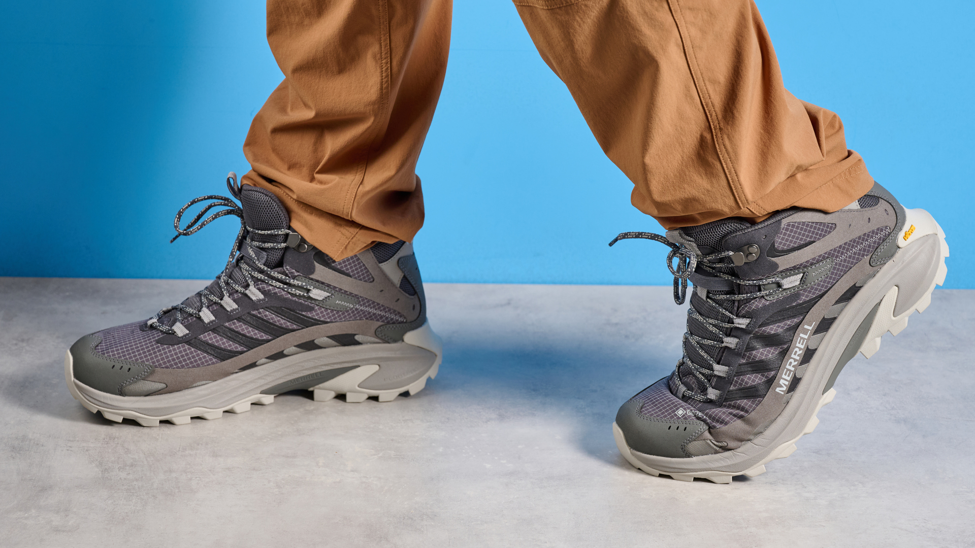 A photo of the Merrell Moab Speed 2 boots against a blue background
