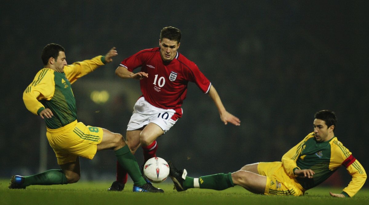 LONDON - FEBRUARY 12: Michael Owen of England skips past Josip Skoko and Paul Okon of Australia during the International Friendly match between England and Australia held on February 12, 2003 at Upton Park in London, England. Australia won the match 3-1. (Photo By Scott Barbour/Getty Images)