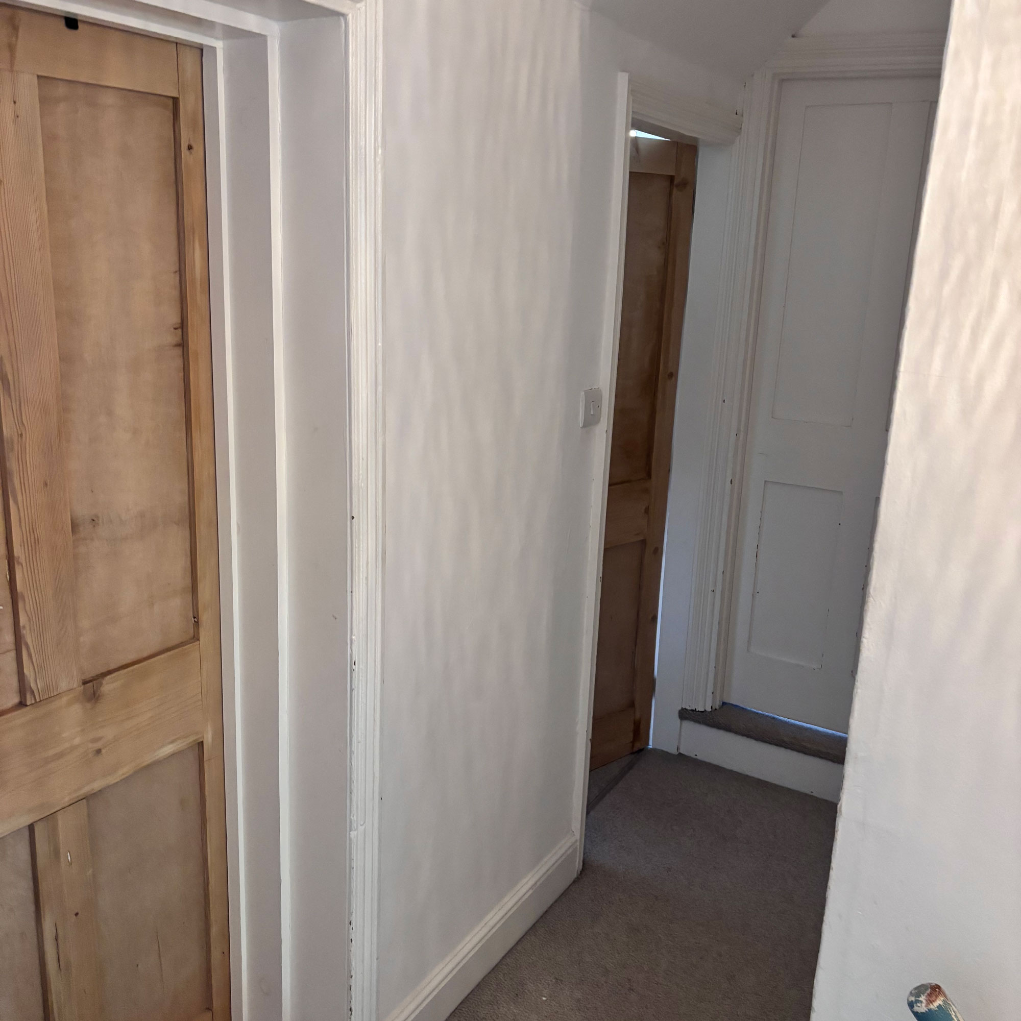 small narrow landing with pine doors