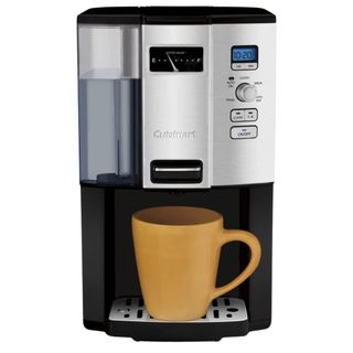Black and silver CuisineArt coffee maker with reservoir visible on left side and yellow cup on tray