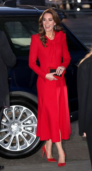 Kate Middleton in a bright red Catherine Walker coat dress and matching accessories at the first annual "Together At Christmas" Carol Service at Westminster Abbey in 2021.