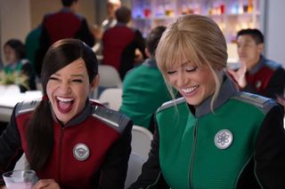 Young Kelly Grayson (Adrianne Palicki) and Lt. Keyali (Jessica Szohr) share some stories about drunken behavior at the Planetary Union Academy.