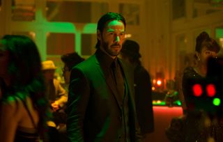 Keanu Reeves as John Wick, standing in a nightclub, in John Wick