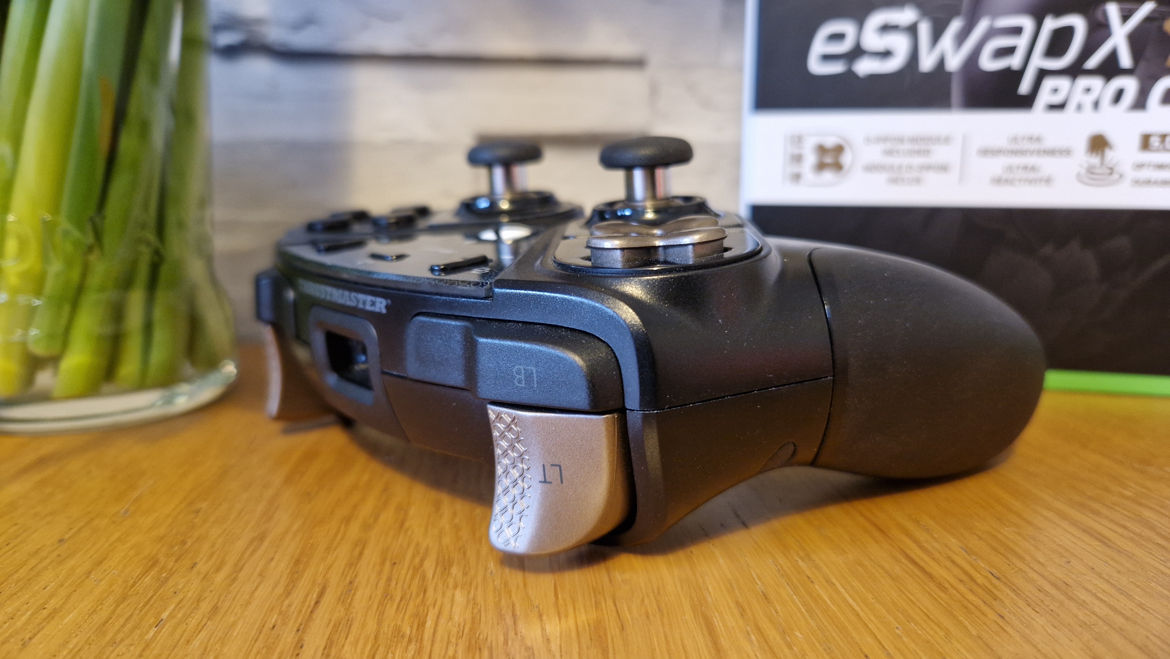 The Thrustmaster eSwap X2 controller on a wooden surface