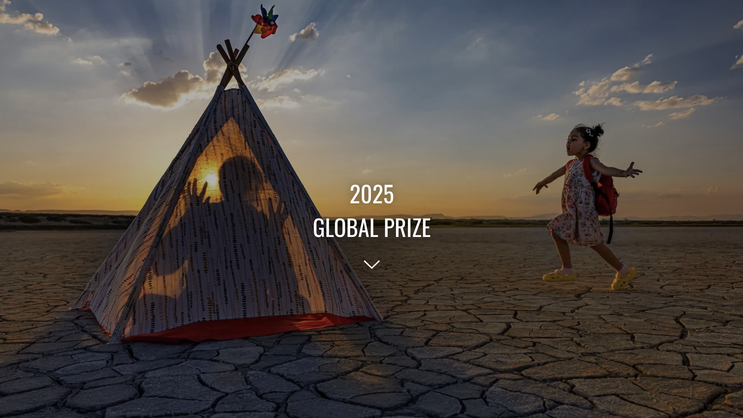 A child in a floral dress walks joyfully towards a colorful tent under a stunning sunset, surrounded by cracked earth