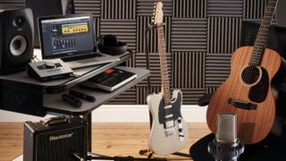 recording studio features electric guitar and amp and acoustic guitar with audio interface and laptop