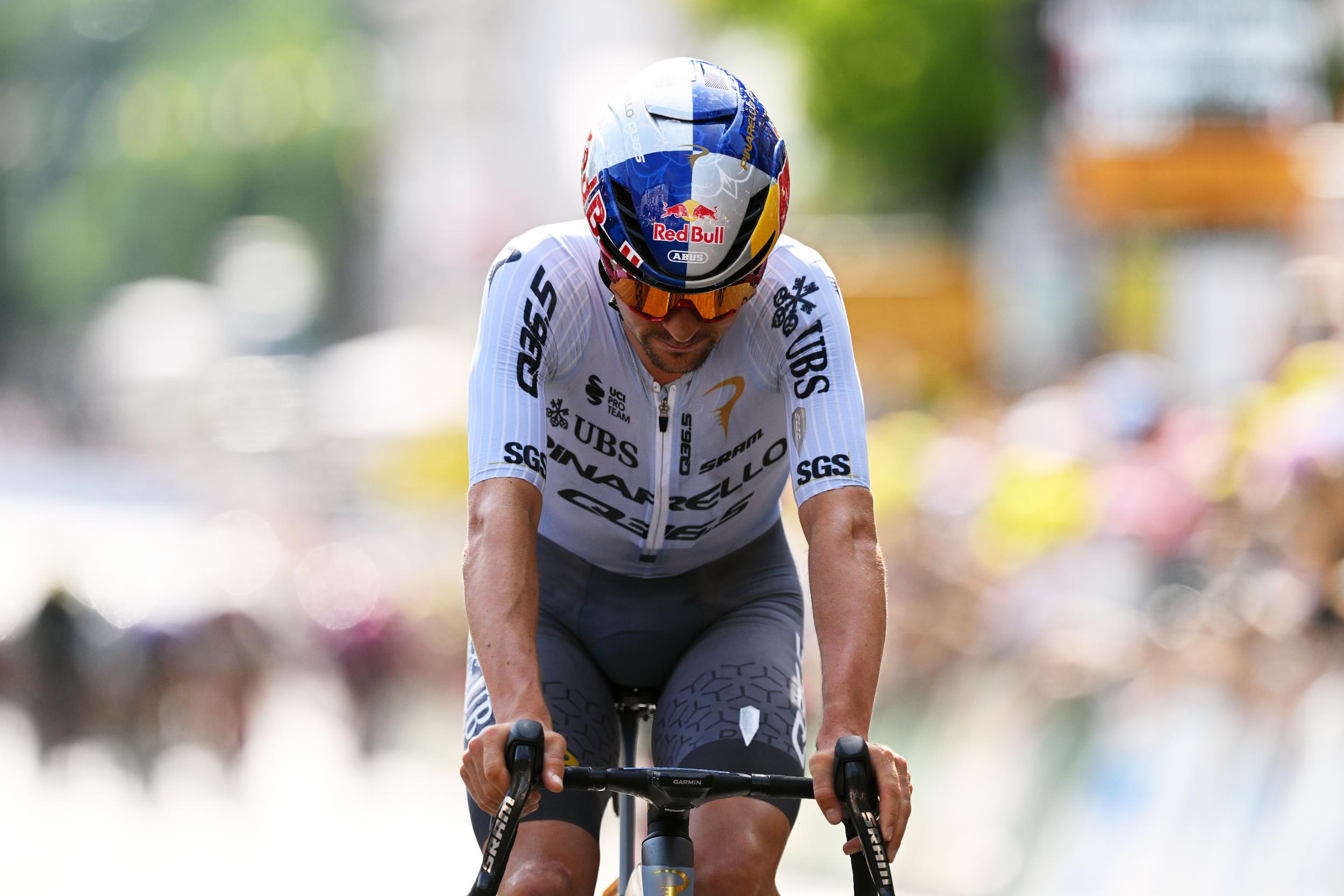 Tom Pidcock crosses the line with his head down, third on stage 9 of 2026 Tour de France