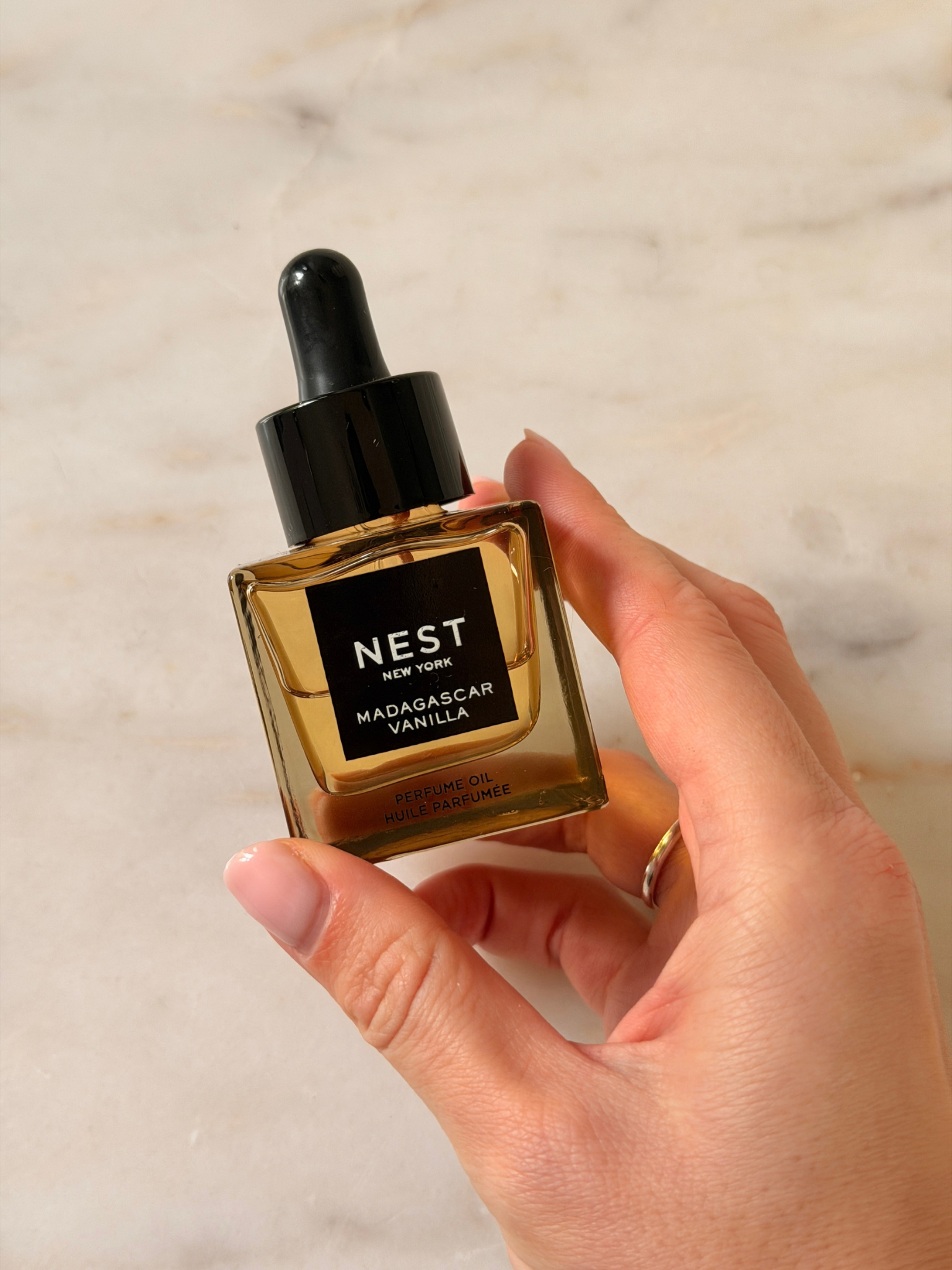 Freelance beauty editor Grace Day holding a bottle of NEST Madagascar Vanilla Perfume Oil