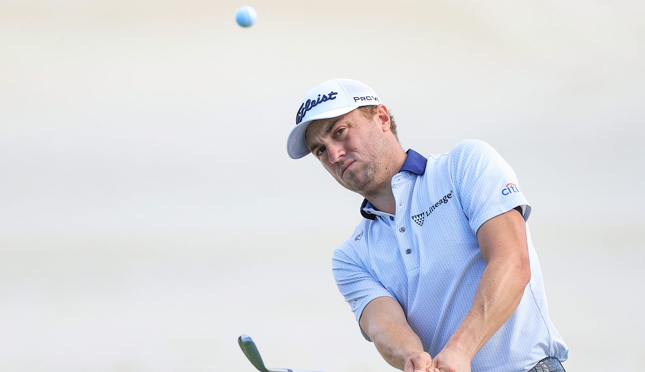 Justin Thomas plays a chip shot and watches its flight