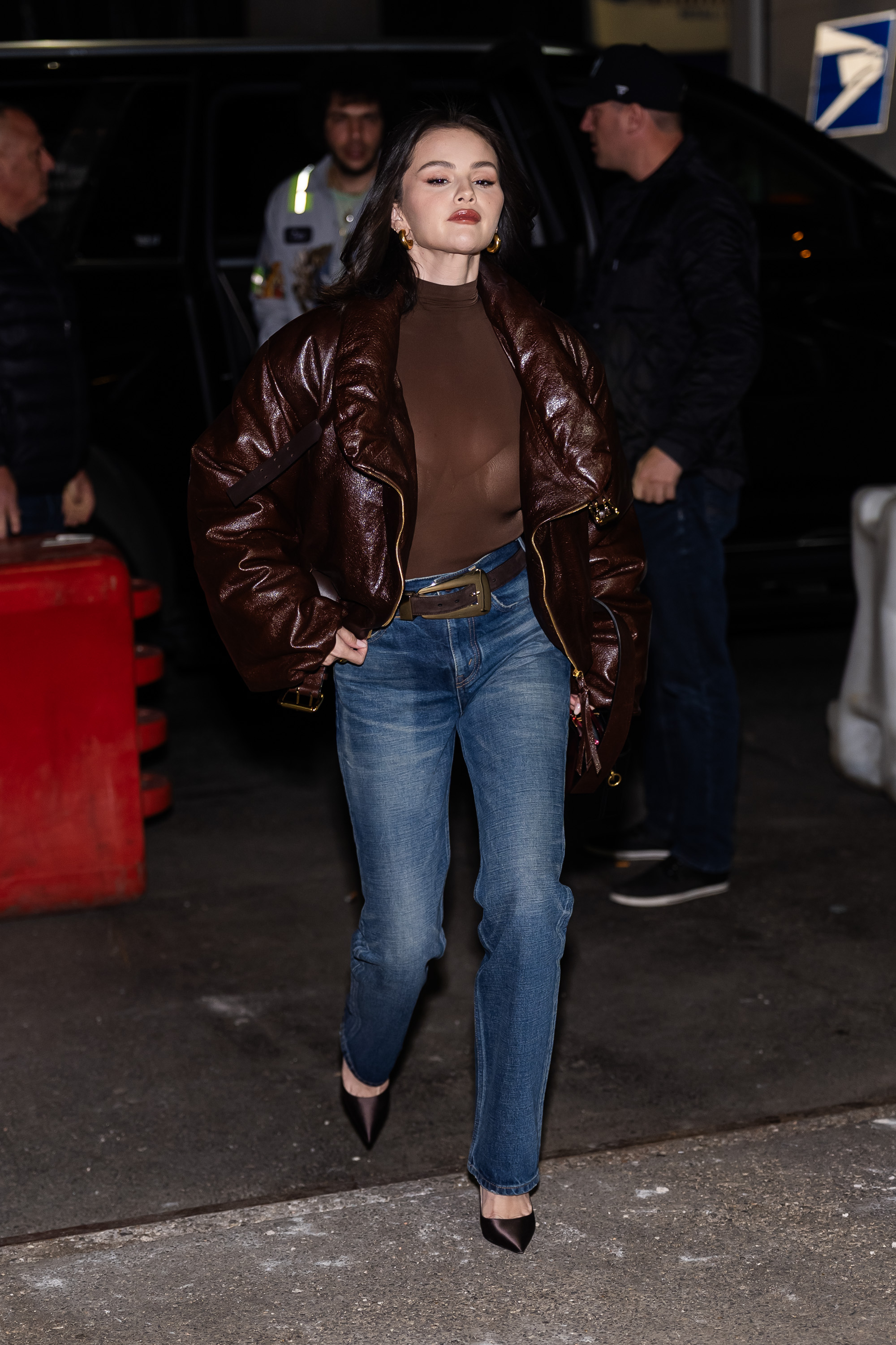 selena gomez wearing a leather jacket, a sheer skirt, jeans, and heels