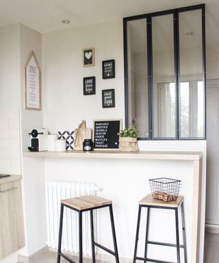 Coffee nook idea with breakfast bar style counter, bar stools and framed typography prints in mono and wood palette.