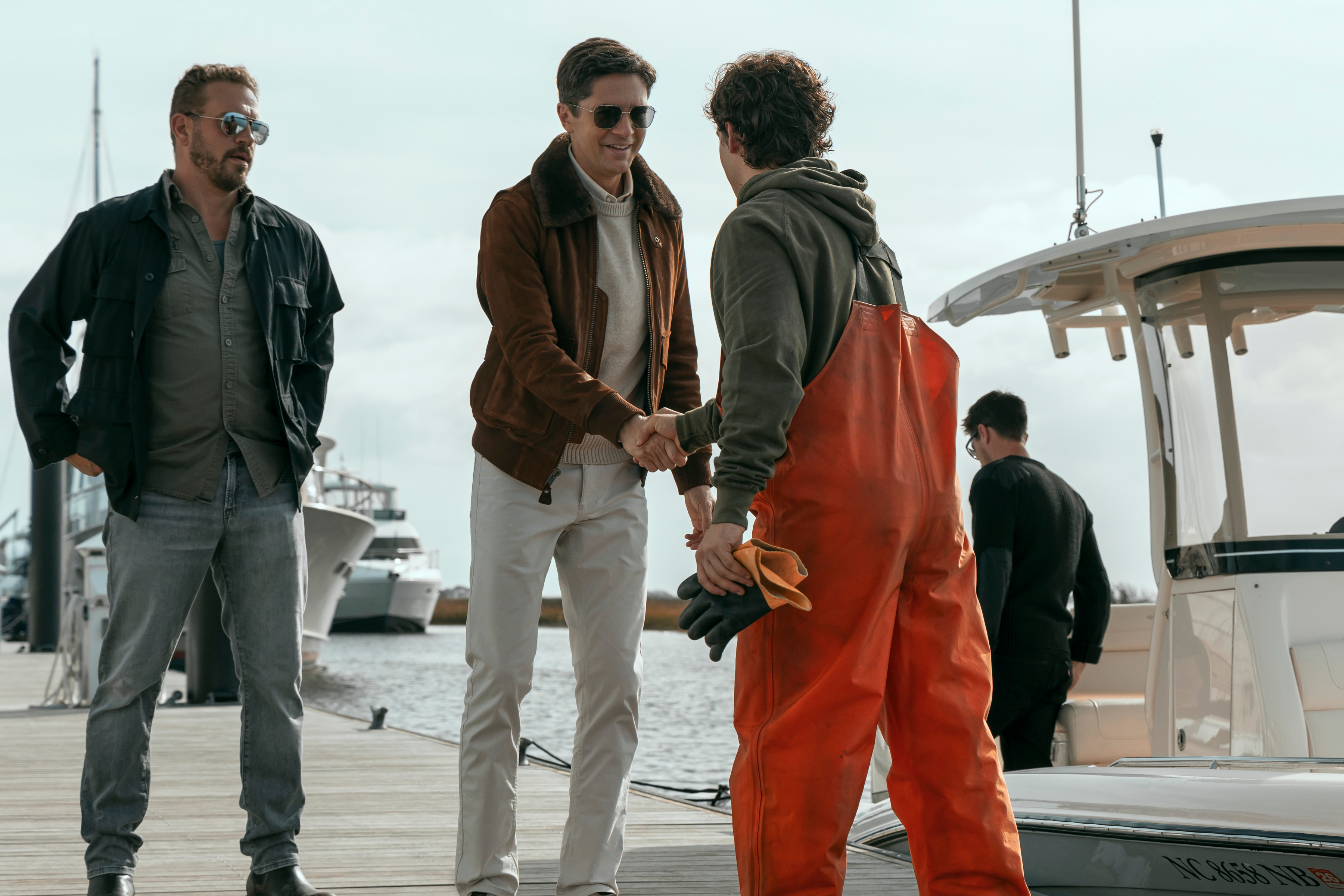 topher grace greeting a fisherman on a dock in a still from the waterfront
