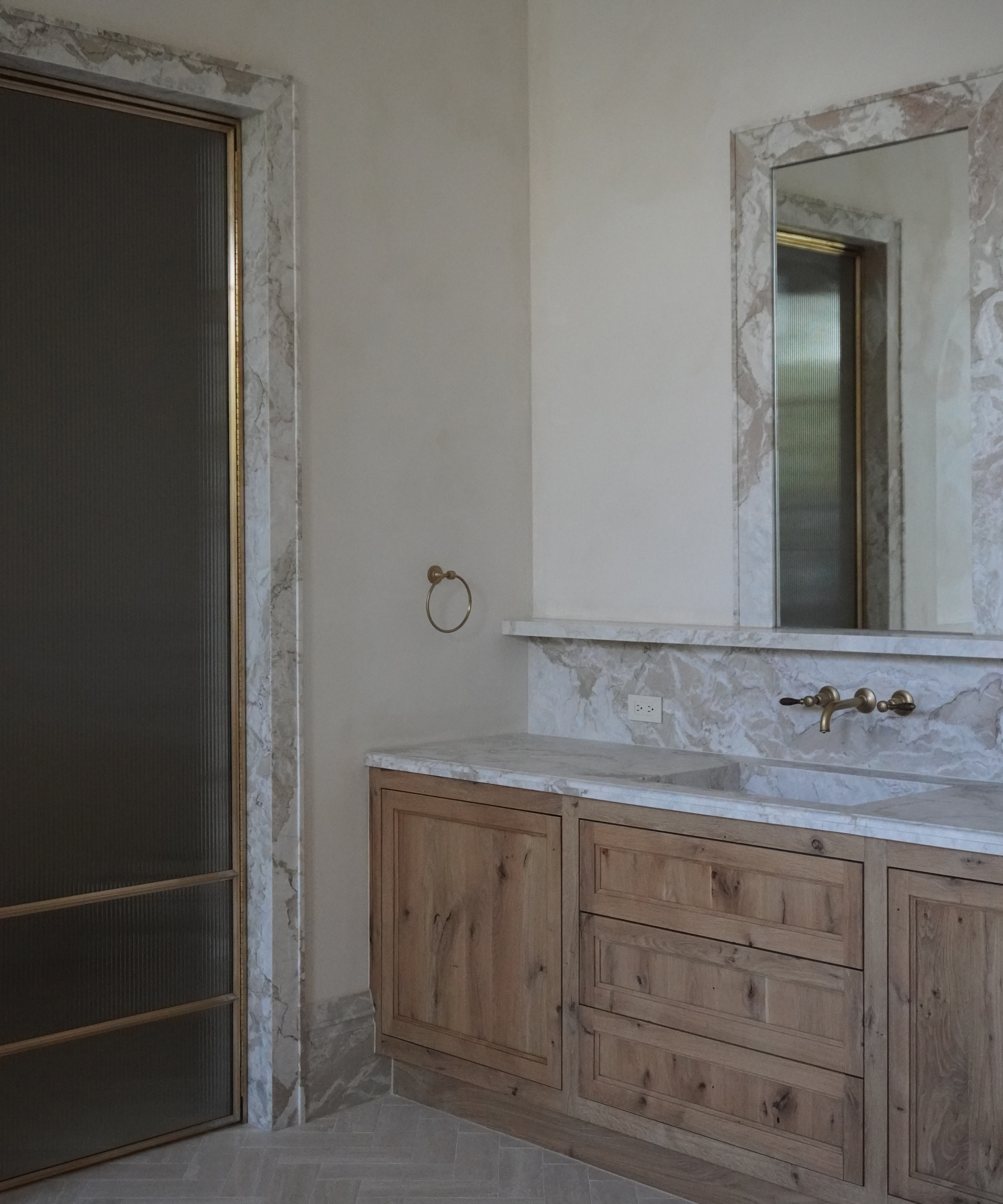 bathroom vanity with marble backsplash and door surround