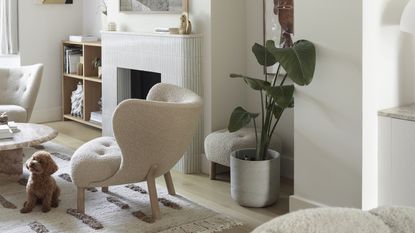 neutral living room with grey blings, white corner sofa with light cushions, a wood and grey armchair and wooden coffee table