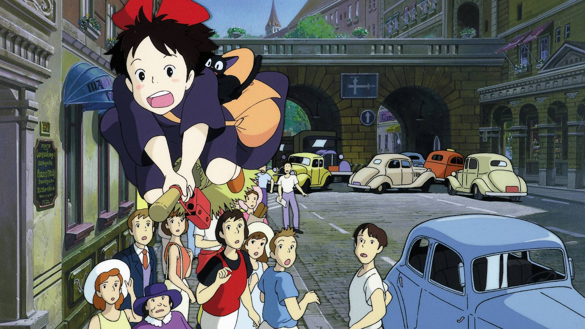 Kiki (Kirsten Dunst) flying her broom over a crowded street in Kiki's Delivery Service