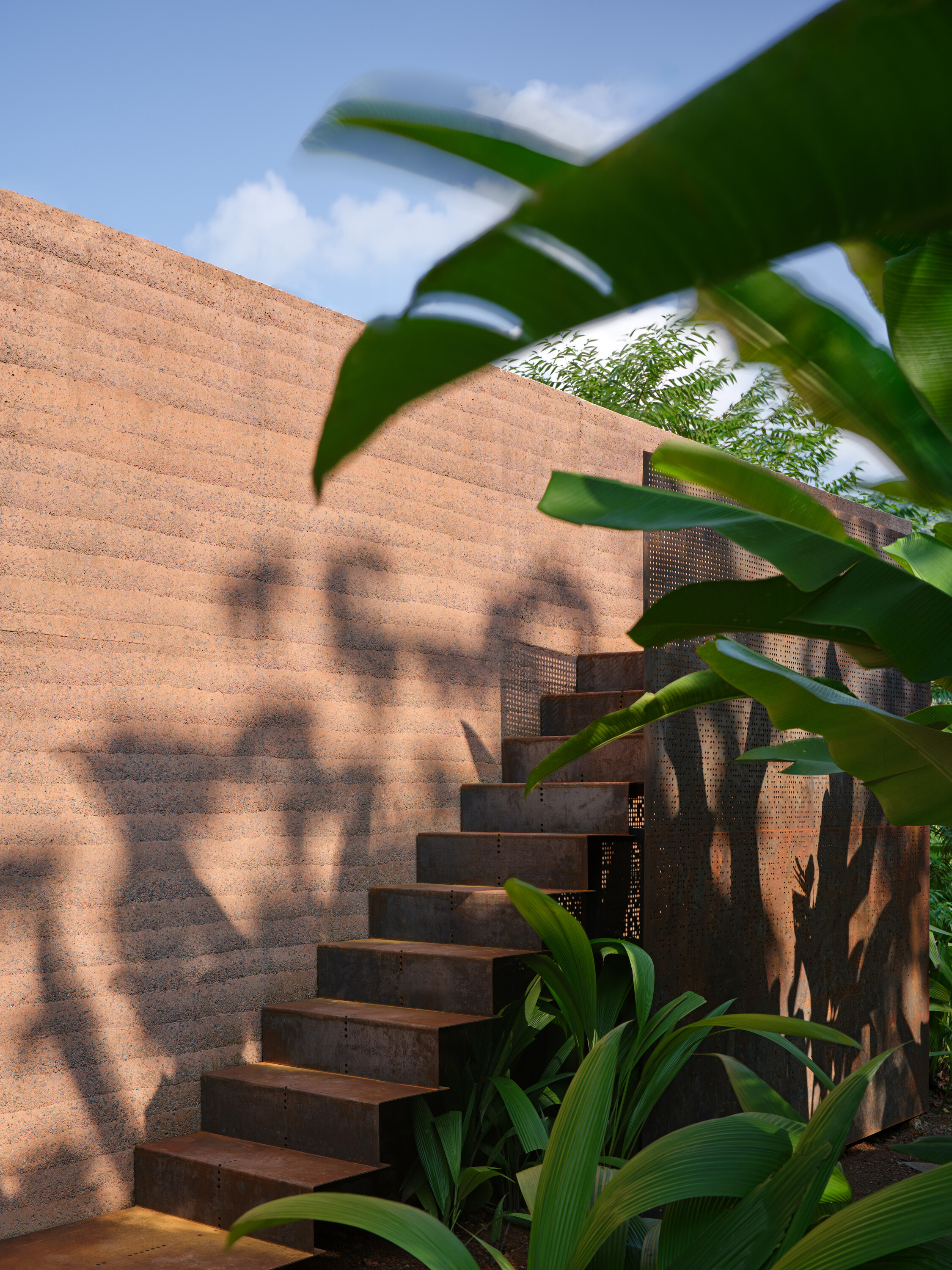 A steel stair leads to the upper roof terrace