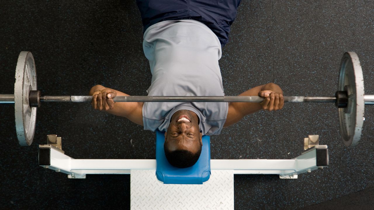 Man doing bench press with barbell