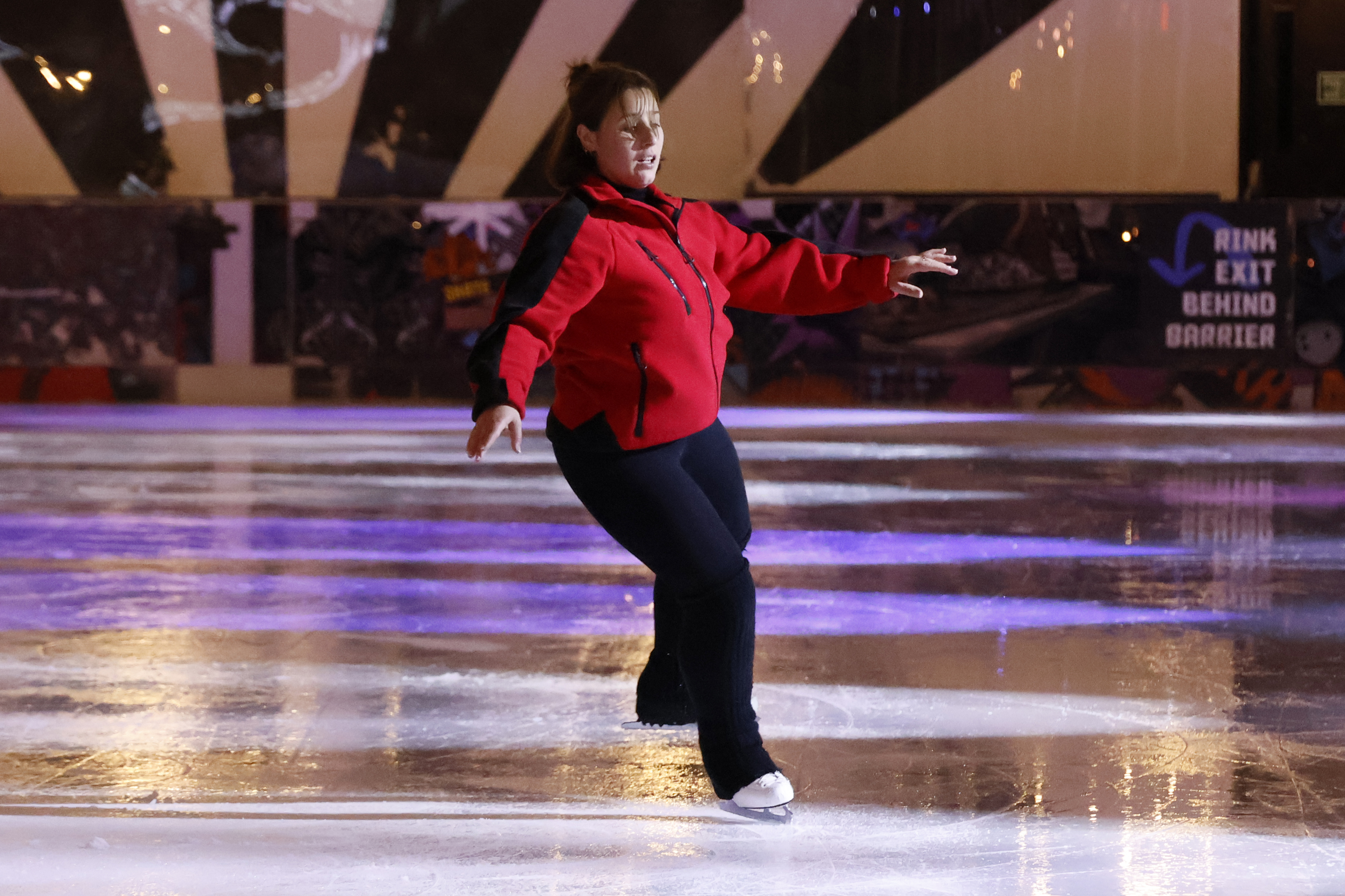 An ice skater performing at an ice rink