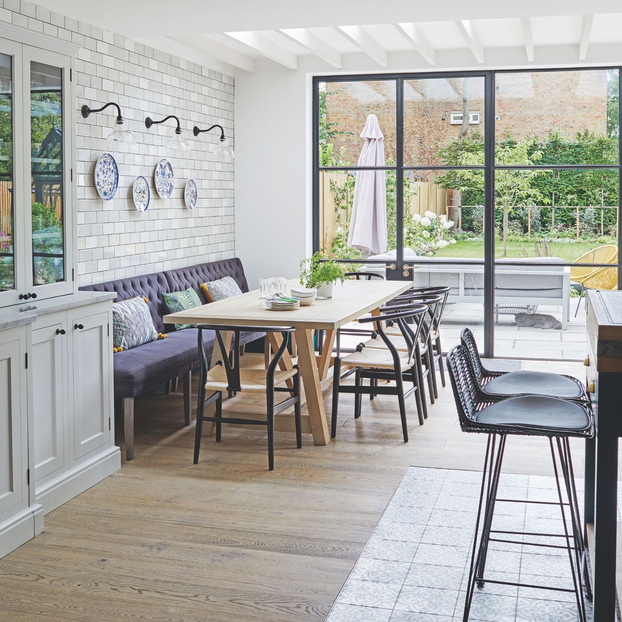 Open plan kitchen-diner with wooden floors and bench seating around a wooden dining table