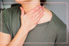 A close up of a woman holding her hand to her neck for an article on how to soothe a sore throat