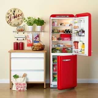 room with white wall and red two door refrigerator