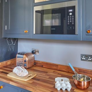 kitchen with grey cabinet and wooden worktop