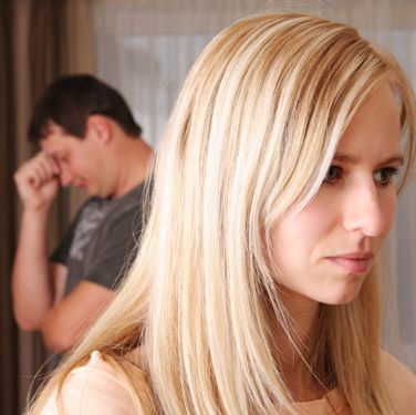 Blonde women with dark-haired man in background