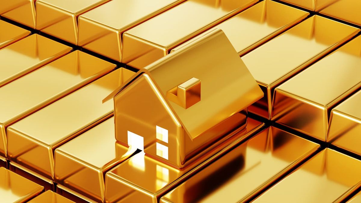 House prices - A small house made from gold on top of other gold bars