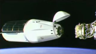 A white and black SpaceX Dragon CRS-29 docks in space with blue Earth blue