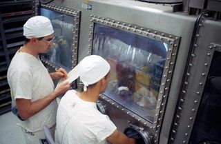 Lab technicians study mice that were injected with lunar material collected during Apollo 11 in a photo taken in August 1969.