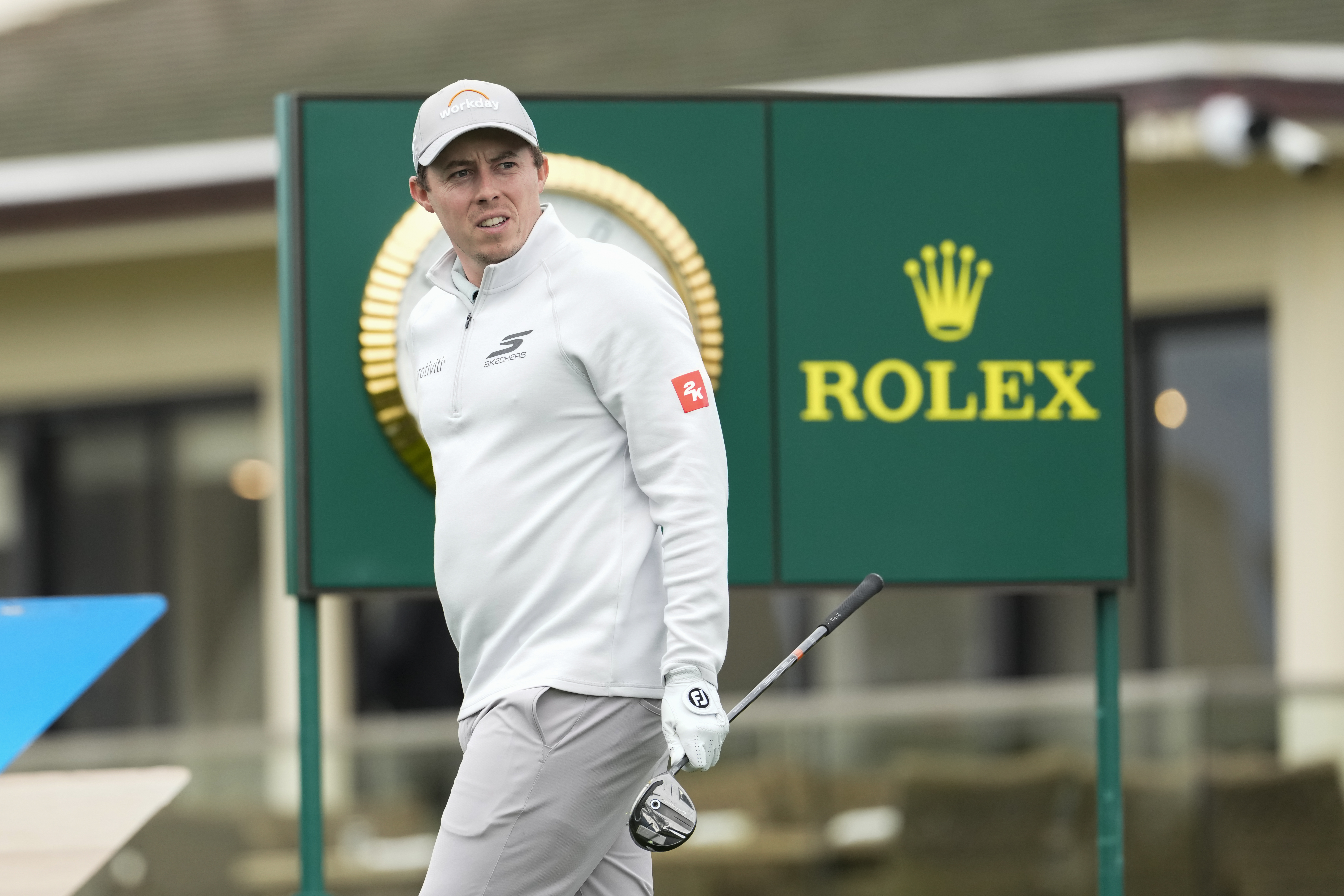 Matt Fitzpatrick walks off the tee holding a fairway wood