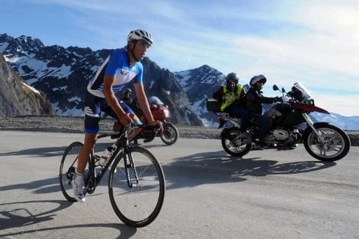 Alberto Contador is chased up the climb by a film crew