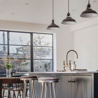 industrial coolicon lights above and island in kitchen with large crittall-style window