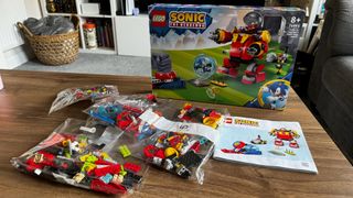 Lego Sonic vs. Dr. Eggman's Death Egg Robot set in bags on a coffee table, in front of the set's box