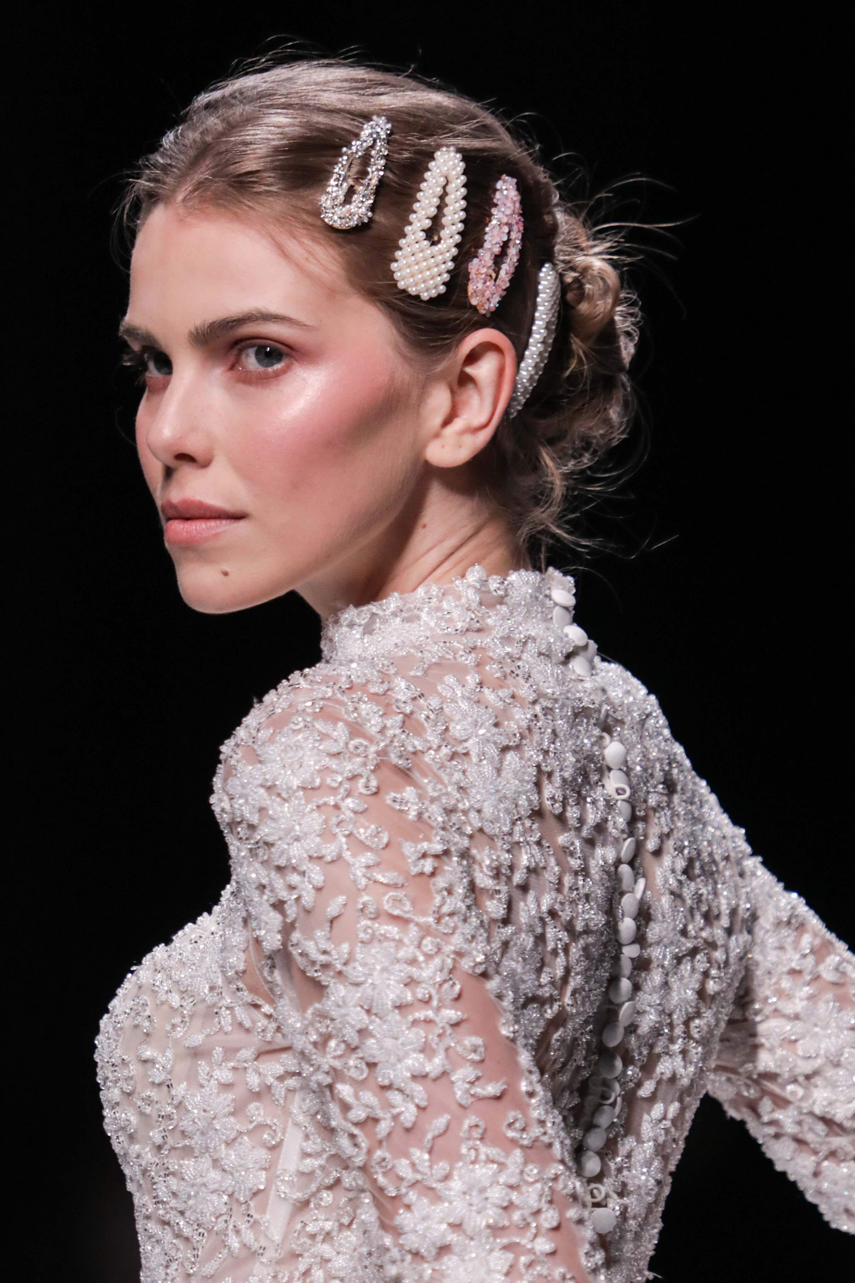 model with a bun hairstyle wearing decorative pearl-embellished snap clips